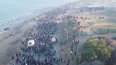 Drone image of thousands of people walking along the Gazan seaside