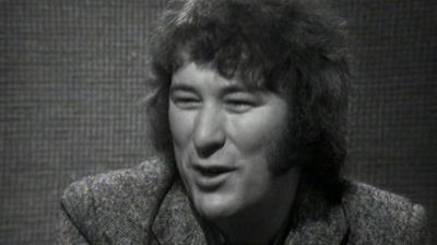 Seamus Heaney sits in a studio.