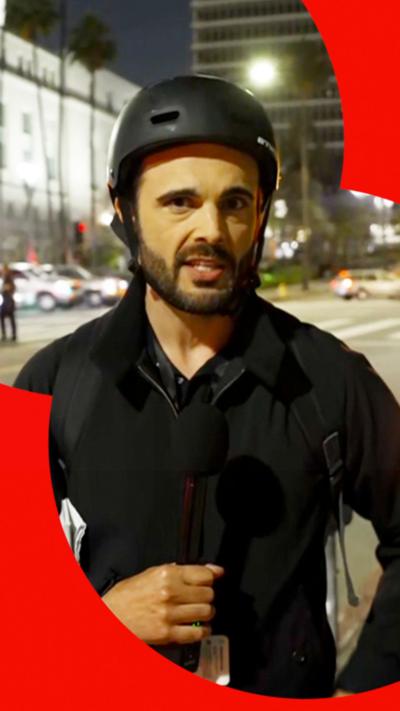 BBC correspondent Carl Nasman wearing a helmet on a street at night in LA