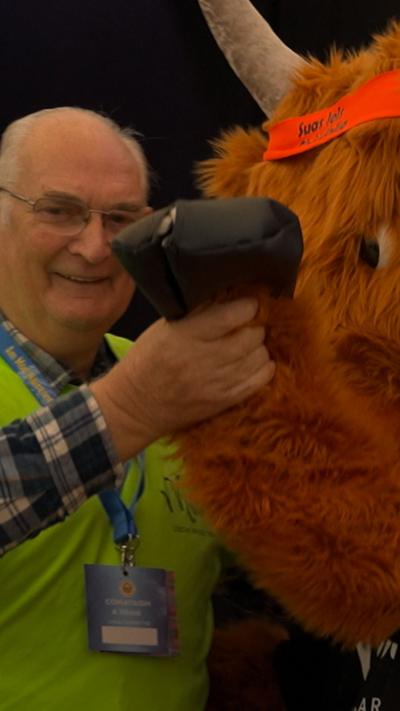 Stiùbhard aig Mòd 2025, a' dannsa le bò.