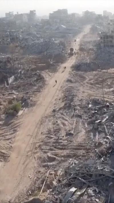 Flattened buildings surround a dusty path 