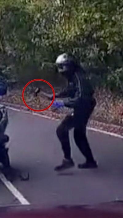 Dashcam video shows a man wielding an axe. He is wearing a bikers helmet