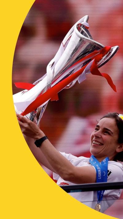 Arsenal manager Renee Slegers lifts the trophy and smiles