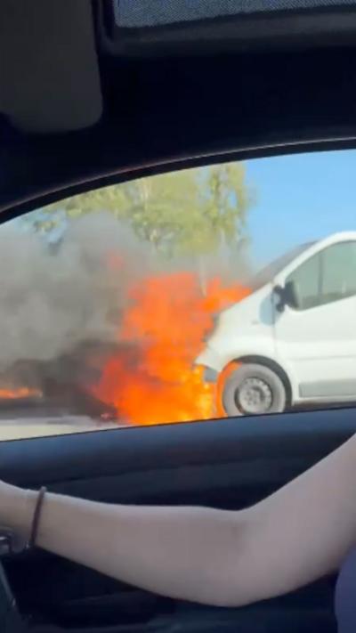 White van on fire at the side of the road