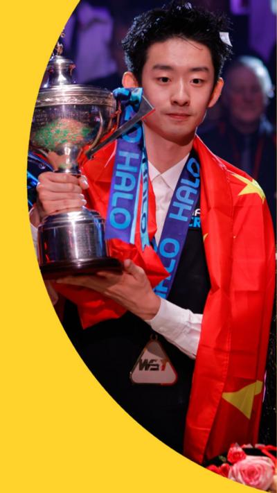 Wu Yize is draped in the Chinese flag and stands holding his trophy.