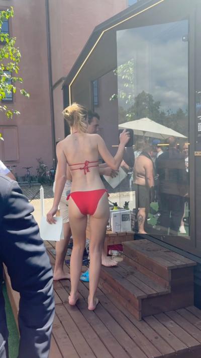 Woman in red bikini walks into a sauna 