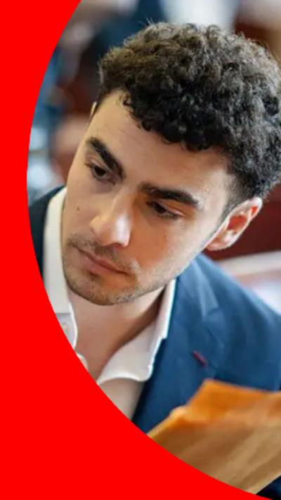 Luigi Mangione appearing in a suit in court, pictured up close 
