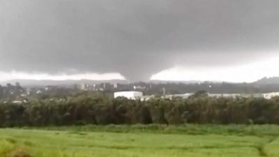 A wide shot showing a tornado-like storm in the distance