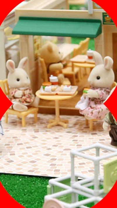 A display of Sylvanian Families toys, with two bunnies sitting at a table eating lunch.