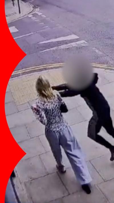 CCTV image of a blurred person stealing a woman's phone as she walks on a pavement