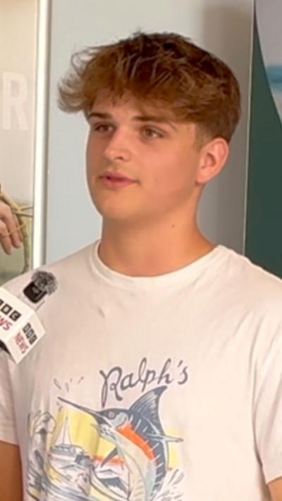 Ollie wears a illustrated white shirt with the words 'Ralph's'
