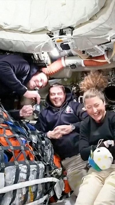 Three of the Nasa astronauts laughing while speaking to earth from the Artemis II