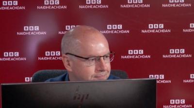 An t-Oll Conchúr Ó Giollagáin ann an stiùidio rèidio