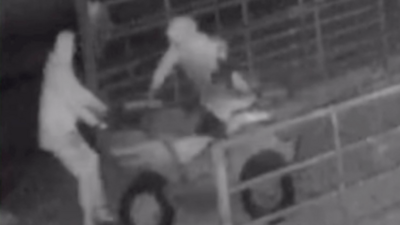 Black and white grainy CCTV image of two thieves stealing a quad bike from a farm shed