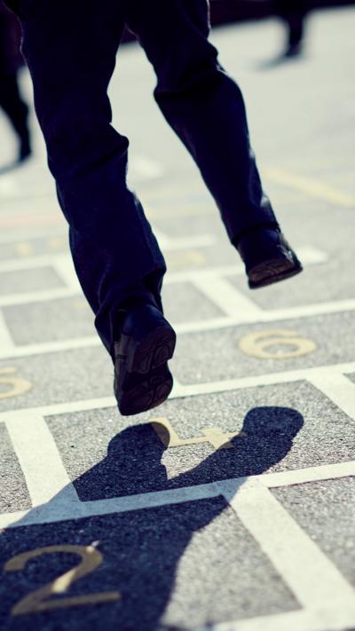 Child playing in school wearing trousers.