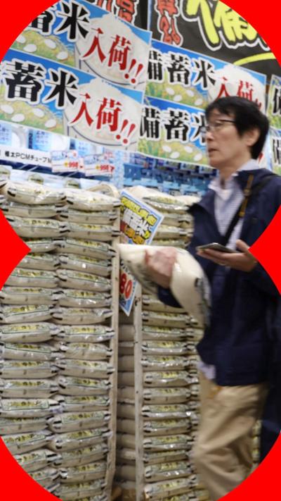 A customer walks past sacks of rice in a supermarket.