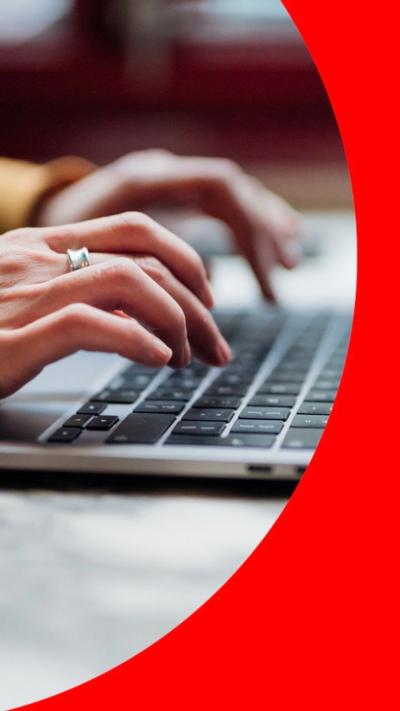 A woman's hands tapping a keyboard.