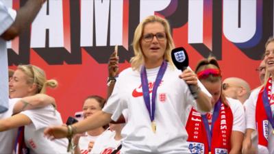Sarina Wiegman dancing holding a mic