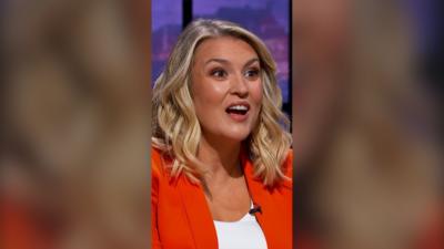 Dragon Sara Davies has shoulder length wavy blond hair and wears an orange blazer over a white top