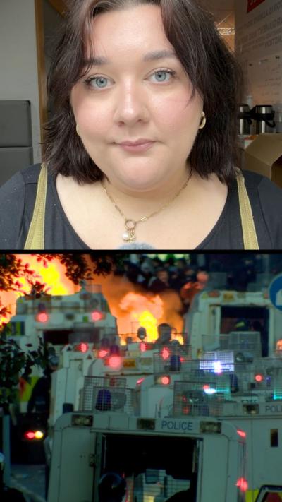 Jessica Lawrence has dark shoulder length hair. Below here is a riot scene showing police riot vans and a fire in front of them. 