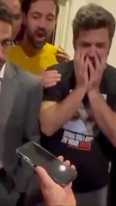 Person holding phone and man with hands on his face