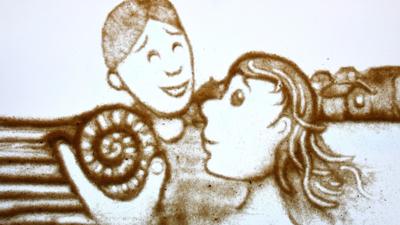 Sand illustration of two people looking at an ammonite fossil