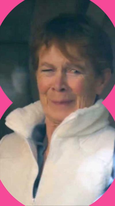 Celia Imrie smiles awkwardly. She has short brown hair and wears a white body warmer 