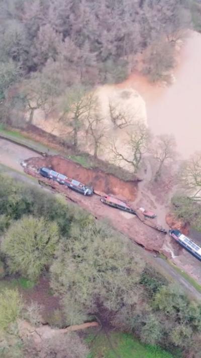 Drone footage of a collapsed canal with stricken narrowboats trapped