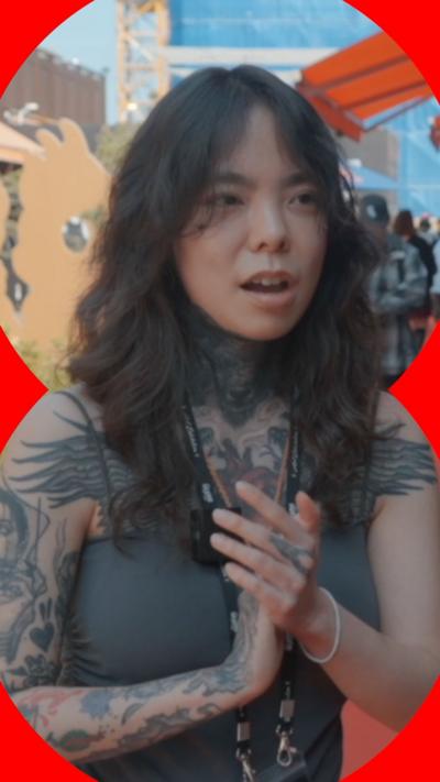 Woman with brown hair and with tattoos on her chest and arms