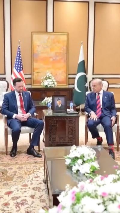 JD Vance and Shehbaz Sharif sit down, with the US and Pakistan flags behind them.