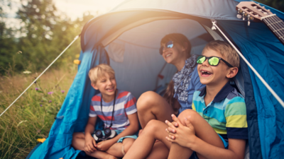 three kids camping and laughing together