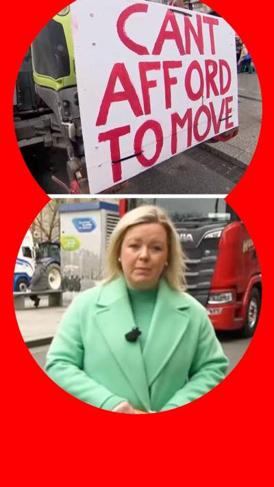 Sara Girvin in a green coat stood in a road next to stopped lorries.