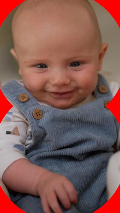 Baby Theo smiling at the camera 