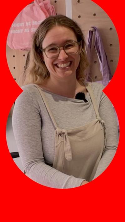 A woman in dungarees smiles. 