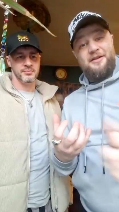 Two men stood next to eachother wearing hats