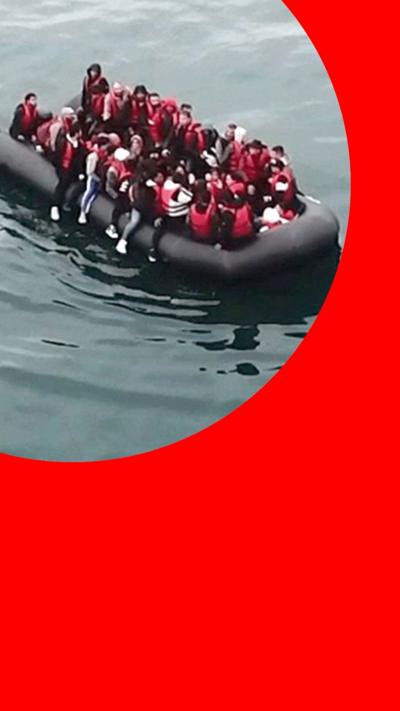 An image of migrants wearing red lifejackets in an inflatable boat, in BBC Verify branding.