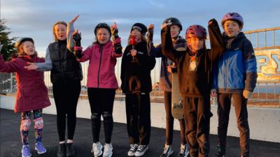 Cuid de chlann-nighein Club Òigridh a' Chnuic aig a' phàirc-spèilidh agus iad làn toileachas.