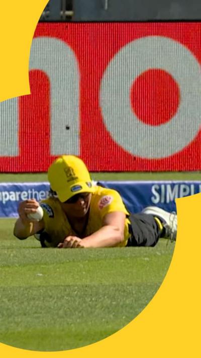 Emma Jones lies on the floor holding the ball after making a catch