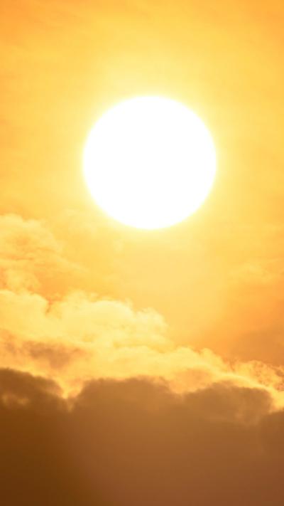 The sun rises in a light orange sky