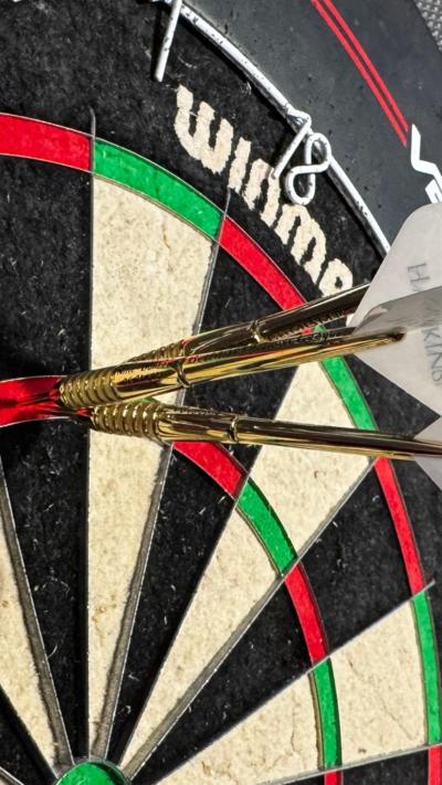 Three golden darts in the Treble 20 segment of a dartboard.