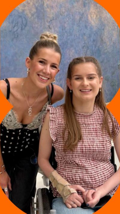 Two girls with blonde hair, one is wearing a black and white top the other is wearing a red and white checked top 