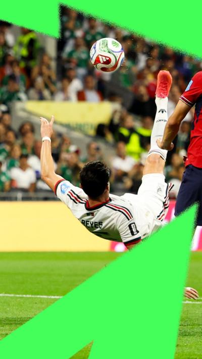 Action shot as Mexican player Israel Reyes bends over backwards with his leg in the air to kick the ball on the pitch of Mexico City Stadium