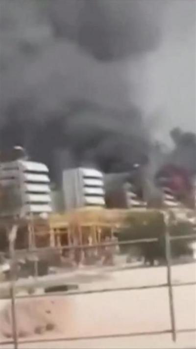 Smoke is seen rising above a series of grey structures at the plant