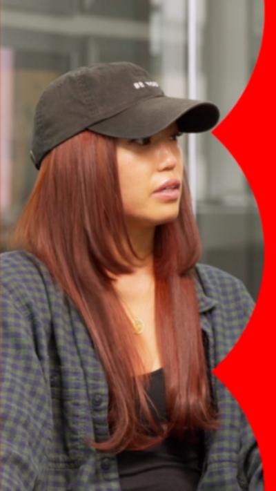 Jennifer An wearing a black baseball cap and a checkered shirt.