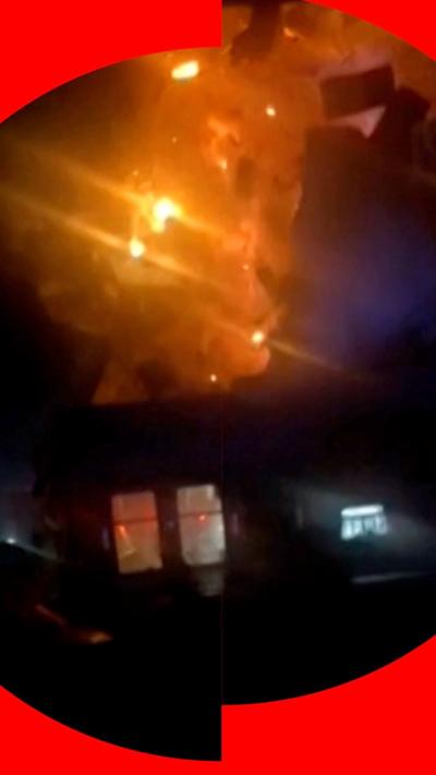 Building exploding at night, engulfed in fire