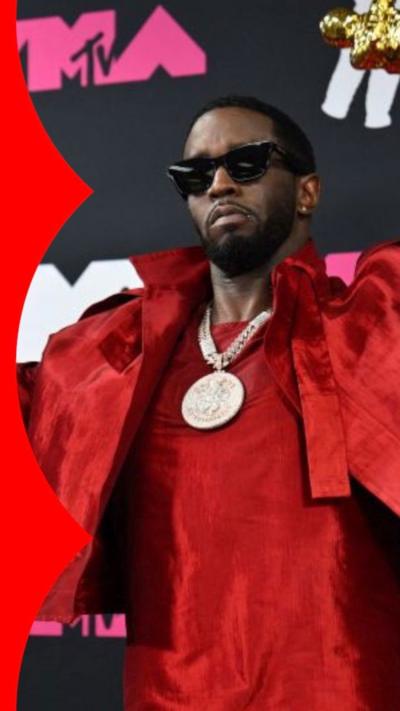 Sean "Diddy" Combs in a red suit posing on red carpet at the 2023 MTV Music Awards.