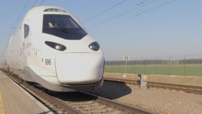 white double decker train sits on train tracks