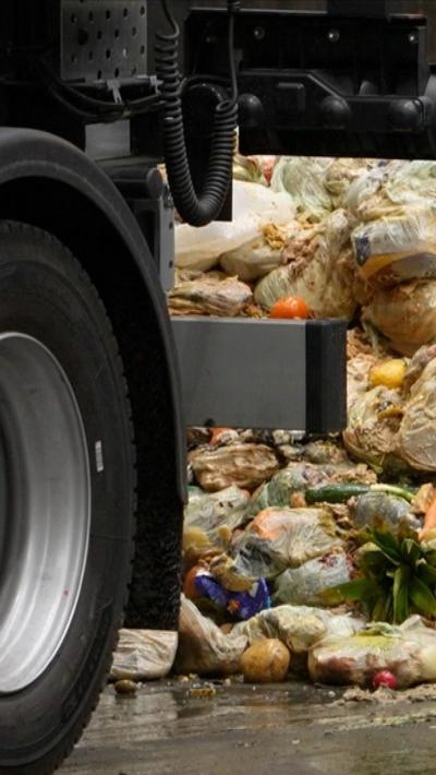 The back wheel of a lorry which is tipping out food waste at a recycling centre