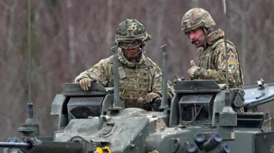 Prince William (right) wear camouflage on top of tank while visiting army base in Estonia