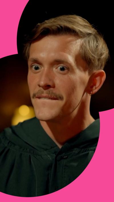 A man with brown hair and and moustache, with a surprised look on his race. 